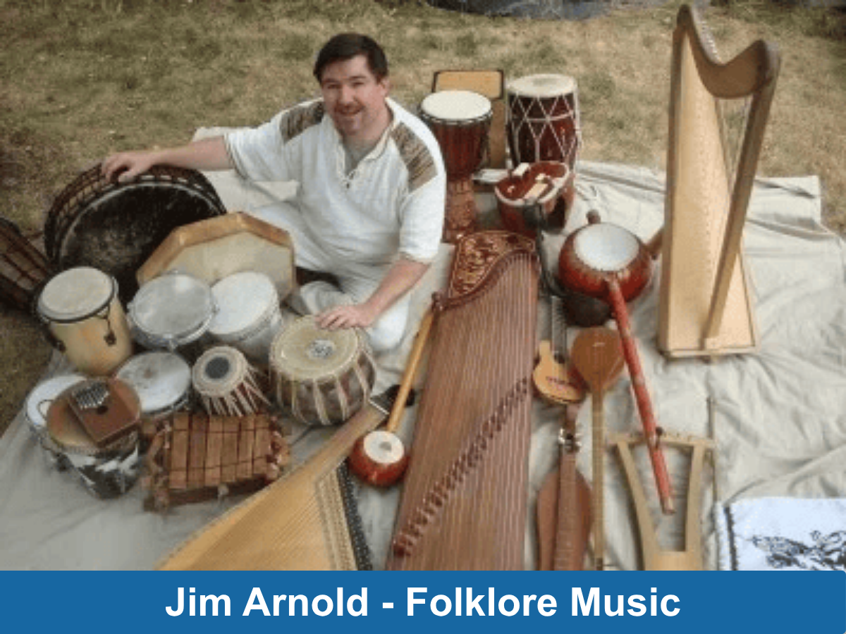 man sitting outside surrounded by handmade musical instruments